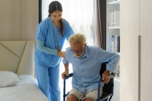 Asian,Smiling,Nurse,Helping,Senior,Man,Get,Out,Of,Bed